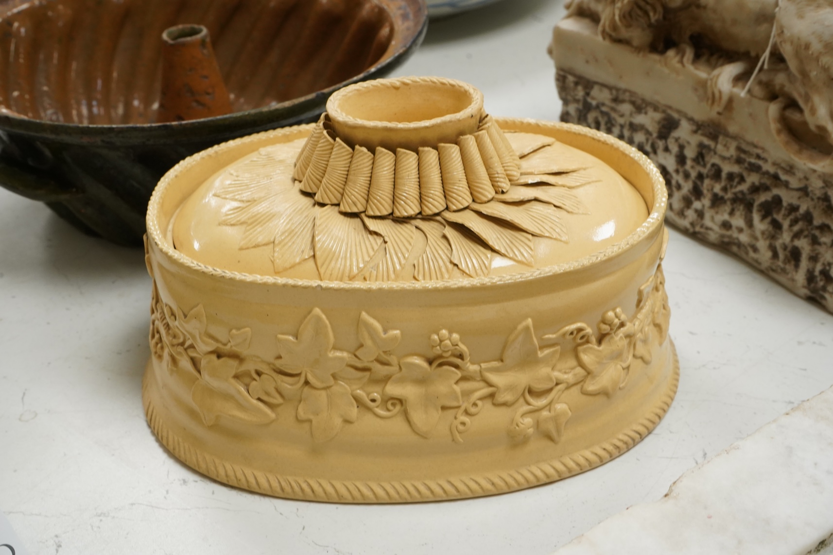 A 19th century oval caneware game/pie dish and cover, 24cm wide with an antique cake mould, (2)